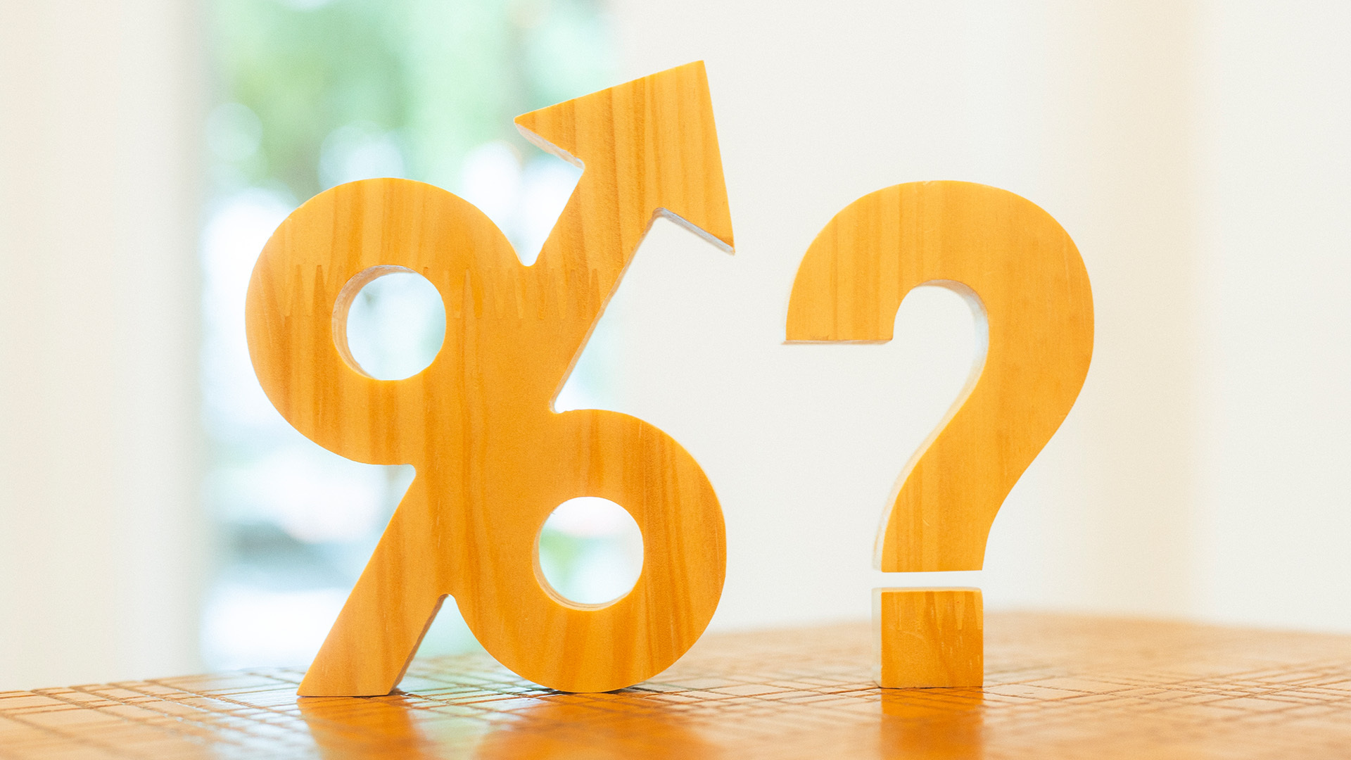 Simboli in legno di una percentuale con freccia verso l'alto e un punto di domanda, rappresentanti le incertezze della pensione pubblica e le opportunità del fondo Fopen.